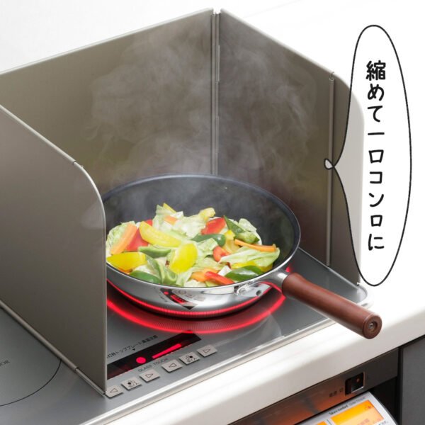 [下村]可伸縮防油板放在電子爐旁邊，圍着正在煮餸的鍋具。