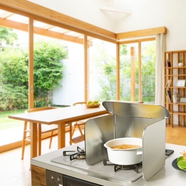 日本製 LEYE 四面不鏽鋼擋油板放在電子爐具上慰藉一個白色的鍋具的場景圖。背景是天然木設計的飯廳。
