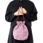 阿美Littly My 粉紅色絎縫抽繩袋拿在手裡的樣子