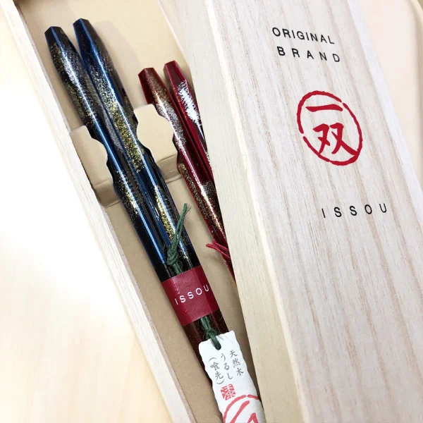 Issou 一雙煙火若狹塗夫婦對筷放在木禮盒裏面，蓋子半打開放在盒子上。