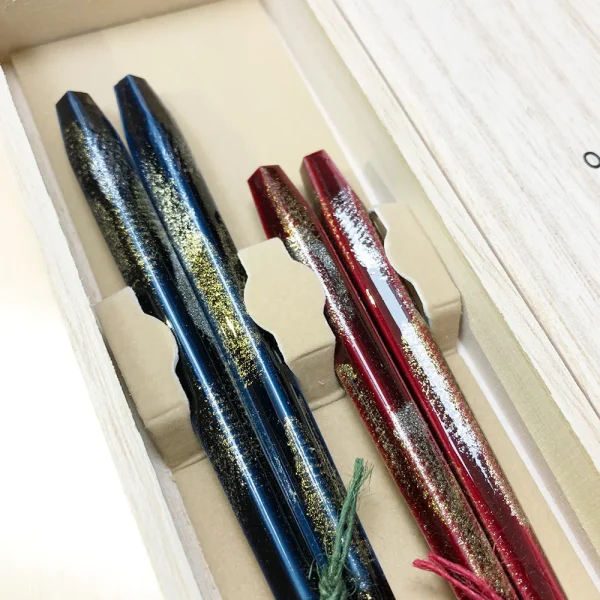 Issou 一雙煙火若狹塗夫婦對筷禮盒裝筷子放在木盒內，筷子頭部的大特寫。