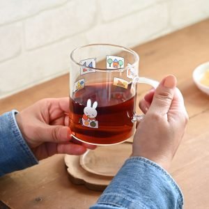 Miffy 耐熱玻璃杯 – 畫畫款,杯子裡裝了茶雙手捧在手裡的樣子