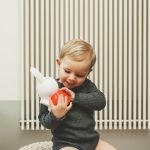 Miffy 造型存錢罐 - 小孩手裡拿着紅色Miffy 造型存錢罐