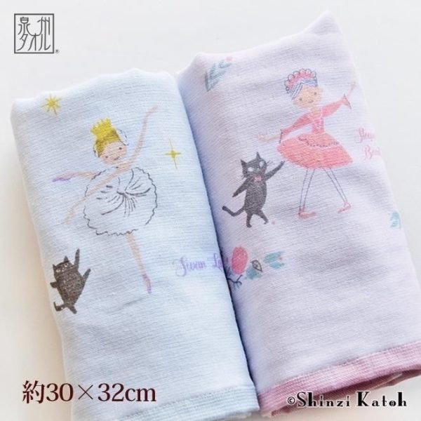 兩條加藤真治芭蕾舞面巾，藍色為《天鵝湖》主題，粉紅色為《睡美人》主題，均折疊展示。 Two Shinzi Katoh ballet towels, blue for Swan Lake and pink for Sleeping Beauty, both folded.