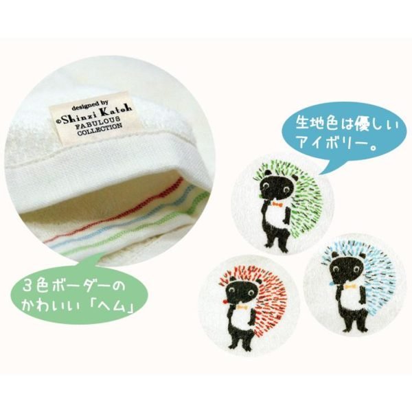 顯示毛巾邊緣的照片，帶有設計師 Shinzi Katoh 的標籤，展示三種顏色的動物圖案。 Photo showing the edge of the towel with the designer's label, featuring three different colors of the animal pattern.