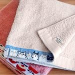 特寫兩條毛巾,清楚展示邊緣設計和毛巾背面的標籤細節. A close-up of two towels, clearly showcasing the edge designs and the label on the back of the towels.