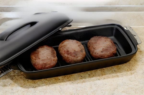 日本製造陶瓷烤盤內含3個漢堡扒，擱放在檯面上。 Japanese-made ceramic baking tray containing three hamburger patties, placed on a countertop.