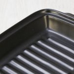 特寫顯示日本製造陶瓷烤盤的邊緣和內部底部的細節. Close-up showing the edge and the details of the inside bottom of a Japanese ceramic baking tray.