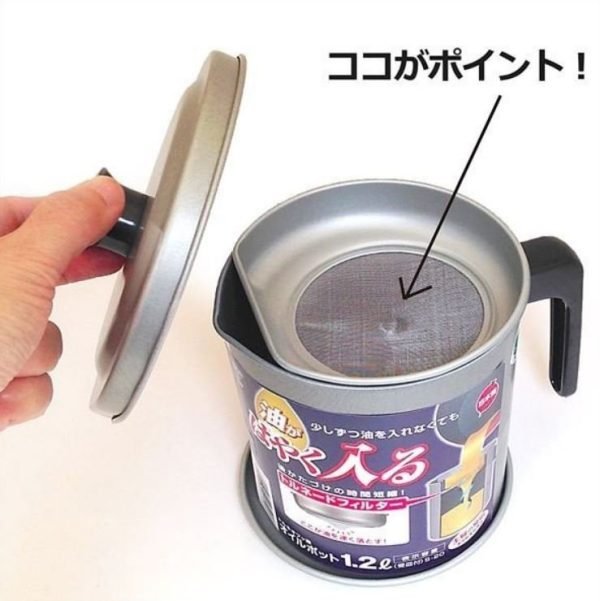 手提起蓋子，顯示日本竹原隔油壺內部的油過濾器. A hand lifting the lid reveals the oil strainer inside the Japanese Takehara Oil Pot.