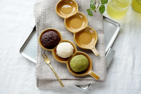 兩個Yoshizawa 益子燒糰子長盤在托盤上，左側有三個糰子，右側空盤 - Two Yoshizawa Mashiko-style dango long plates on a tray, with three dango on the left and the right plate empty.