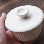 一隻手握著Yoshizawa 益子燒茶碗蒸杯。 / One hand holding the Yoshizawa Mashiko-style chawanmushi cup.