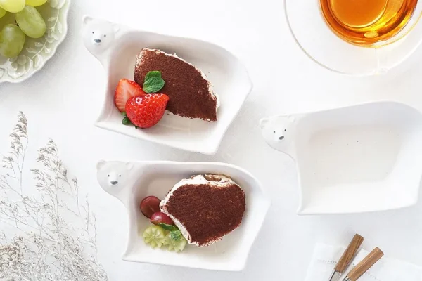 三個Yoshizawa 益子燒北極熊造型小碗放在桌上，左邊和中間的碗裡有甜點，右邊的碗是空的 - Three Yoshizawa Mashiko-style polar bear-shaped small bowls on a table, with the left and middle bowls containing dessert, and the right bowl empty.