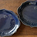 兩個顏色略有不同的Yoshizawa 益子燒橢圓餐盤，左側稍亮，右側稍暗 - Two Yoshizawa Mashiko-style oval plates with slightly different colors, lighter on the left and darker on the right.