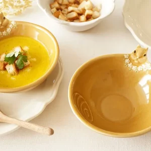 兩個Yoshizawa 益子燒松鼠碗放在桌上，前面的碗是空的，後面的碗裡裝有湯 - Two Yoshizawa Mashiko-style squirrel bowls on a table, with the front bowl empty and the back bowl containing soup