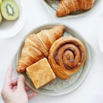 綠色森林圖案餐盤上放着不同形狀的麵包