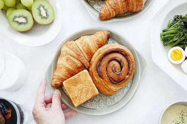 綠色森林圖案餐盤上放着不同形狀的麵包