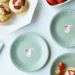 幾個兔子與草莓餐盤放在台上的俯視圖，可以清晰看到見到盤子中間兔子捧着草莓的可愛模樣