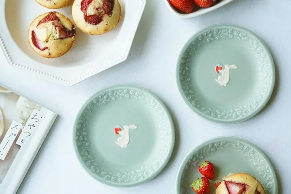 幾個兔子與草莓餐盤放在台上的俯視圖，可以清晰看到見到盤子中間兔子捧着草莓的可愛模樣