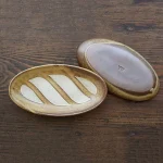 兩個Yoshizawa 益子燒法式面包椭圆盤,面朝上下放在枱上 - Image of two Yoshizawa Mashiko-style oval French bread plates on a table, one facing up and the other down.