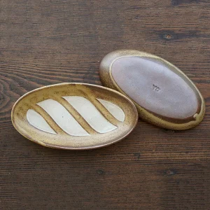 兩個Yoshizawa 益子燒法式面包椭圆盤，面朝上下放在枱上 - Image of two Yoshizawa Mashiko-style oval French bread plates on a table, one facing up and the other down.