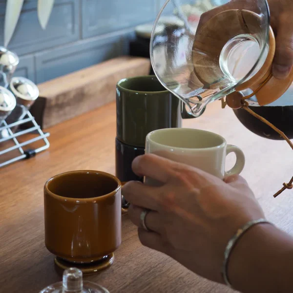 不同顏色的 CHIPS Smith 高腳陶瓷杯正在用於製作咖啡，展示其功能性和美觀設計。 / Different colored CHIPS Smith high-foot ceramic cups being used for making coffee, showcasing their functionality and aesthetic design.