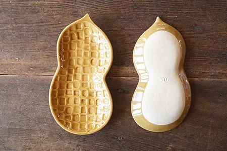 兩個Yoshizawa 益子燒花生造型餐盤平牌放在枱上,一個展示正面、一個展示底部