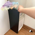 把摺疊起的高木金屬可伸縮擋油板放進櫃的縫隙