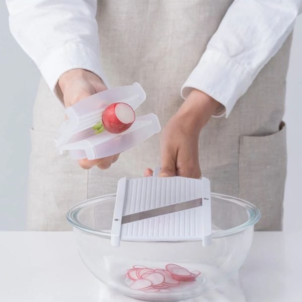 A man's hands holding the SUNCRAFT ultra-thin slicer, demonstrating how to slice red beets