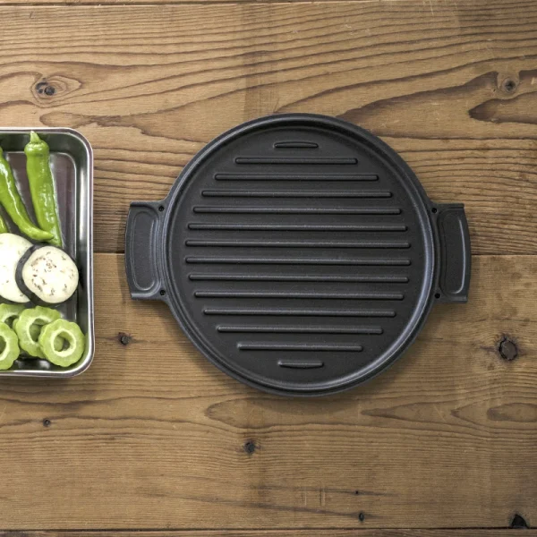 日本製 OVJECT 鑄鐵兩用深型鍋蓋子放在木枱上的圖片