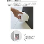 用手從黑色的日本 TOWER 廁紙收納箱旁邊的孔拿出一卷廁紙