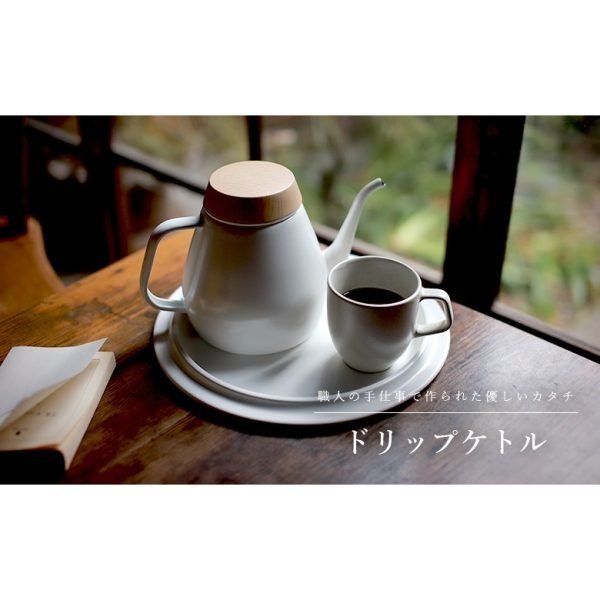 白色日本製 Ovject 搪瓷咖啡壺與杯放在圓形的托盤上，托盤放在窗邊的木枱上