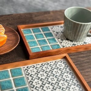 日本製SATOMIMI 咖啡托盤「銀杏」與「堇」款設計的托盤放在木枱上，銀杏款的托盤上放在一杯咖啡