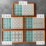 五款不同圖案設計的日本製SATOMIMI 咖啡托盤一起放在灰色枱墊上的正面圖，每款旁邊附有日文設計名稱