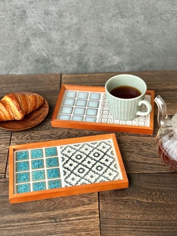 山茶花款與手鞠款日本製SATOMIMI 咖啡托盤一起放在木枱上，旁邊放着一碟牛角包，手鞠款托盤上放在一杯咖啡