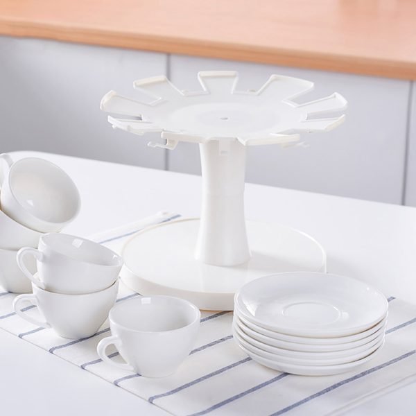 White color TIGER CROWN rotating coffee cup and saucer stand displayed on a table with coffee cups and saucers surrounding it.