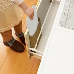 正在將摺起的日本製 BELCA 4截擋油板白色款放進抽屜內