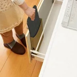 正在將摺起的日本製黑色款 BELCA 4截擋油板放進抽屜內