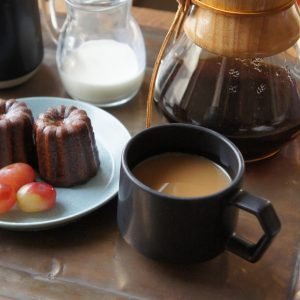 CHIPS Mug 陶瓷杯 280ml - 黑色款裝滿咖啡放在木枱面上，旁邊放着甜點。