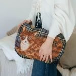 松尾美由紀 貓咪造型抱枕 - Maron 被一位女士攬着放在身旁