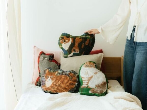 松尾 Miyuki 貓咪造型剪裁抱枕四款不同設計放在床上不同位置的展示圖
