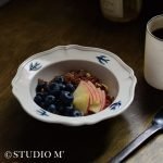 17cm Studio M' Early Bird 燕子系列碗裝着早餐放在深色木枱上。
