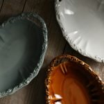 啡色、淺藍色與白色 Studio M' FANETTE 橢圓碗一起放在木抬上的俯視圖。