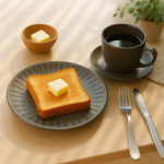 日本製 Tetote美濃燒碟子 灰色款與其他餐具一起放在枱上，碟上放了一塊多士。