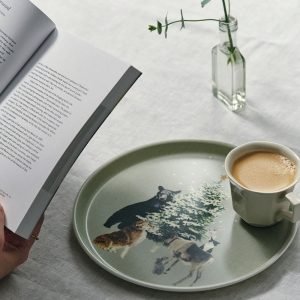 日本製 Fog Linen Work 亞麻面圓形托盤 聖誕限定款式放在枱面，上面放着飲品，旁邊有本打開的書。