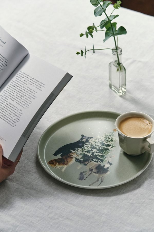 日本製 Fog Linen Work 亞麻面圓形托盤 聖誕限定款式放在枱面，上面放着飲品，旁邊有本打開的書。