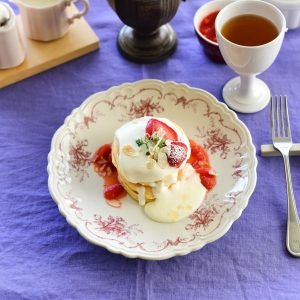 粉紅色款 Studio M’ Moment 圓餐盤 240mm 款裝着食物放在舖了紫色枱布的枱上。