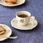 Rosier 圓餐盤 16.5cm 款上放着裝了茶的Rosie茶杯放在枱上，旁邊放了其他裝着甜點的Rosier 圓餐盤。