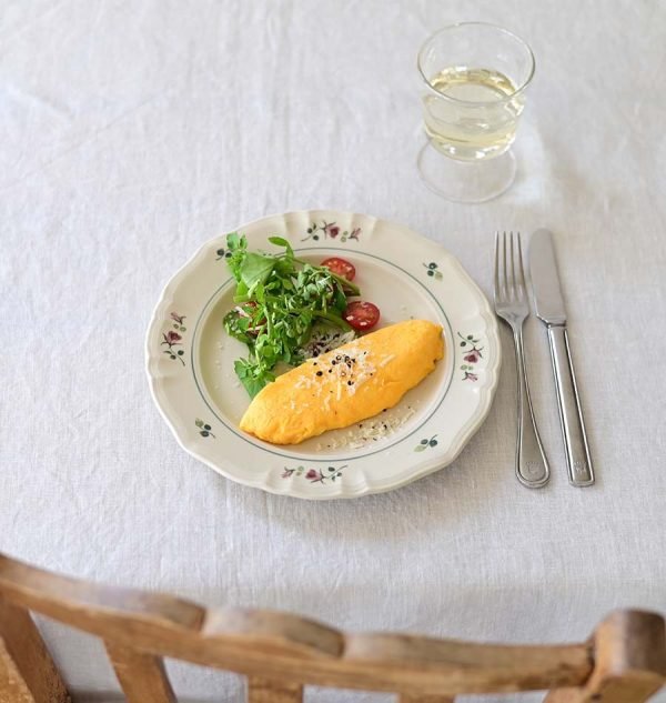 Studio M’ 2025 秋冬新系列 Rosier 圓餐盤裝着食物放在枱面,旁邊有刀叉及飲品。