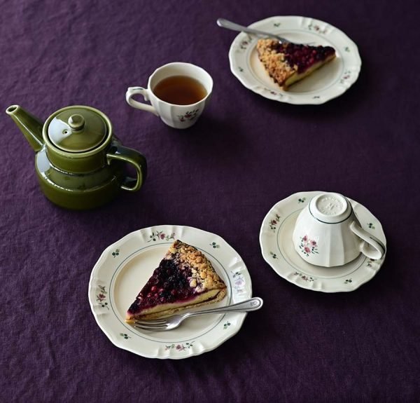 不同尺寸的Rosier 圓餐盤上面裝着甜點與其他餐具一起放在枱面