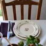 二個大小不同的 Studio M' 2025 秋冬新系列 - Rosier 圓餐盤疊起放在枱面,旁邊有刀叉放在餐巾上。